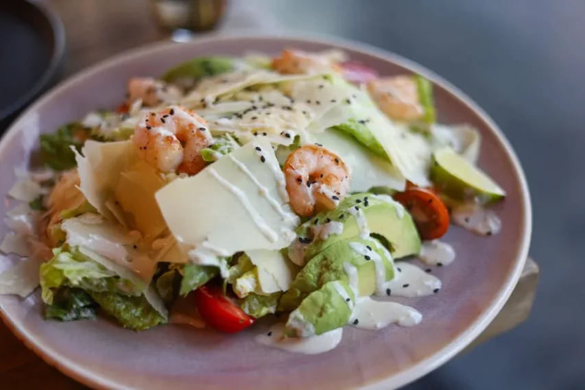 Uma Vibrante Salada Caesar De Camarão E Abacate Com Queijo E Sementes De Gergelim.